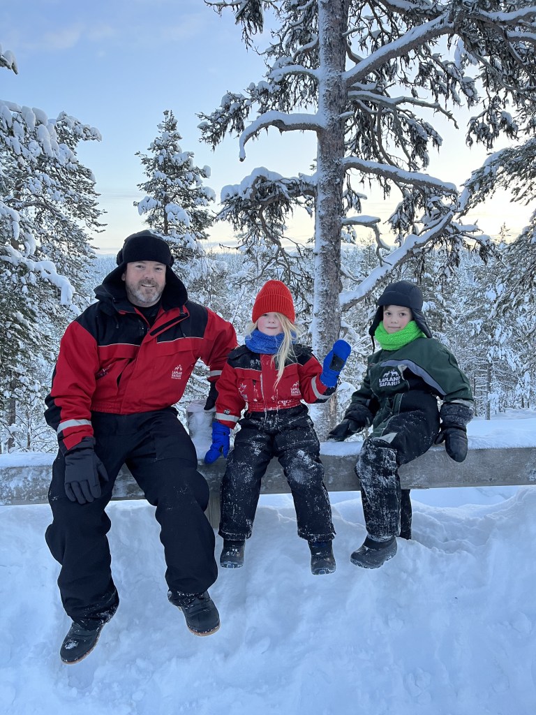 family sitting together in snow