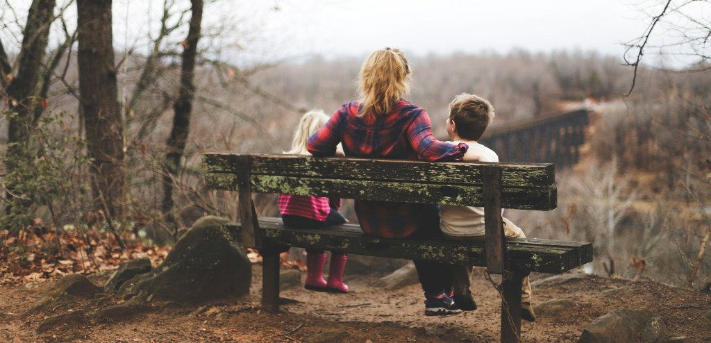 mum sitting with children on a bench
